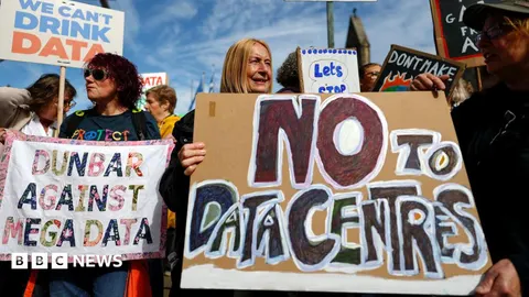 Activists gather protesting against data centres in their local area outside the Scottish parliament on the first Thursday after recess on September 03, 2026 in Edinburgh. One woman is holding a "NO TO DATA CENTRES" placard.